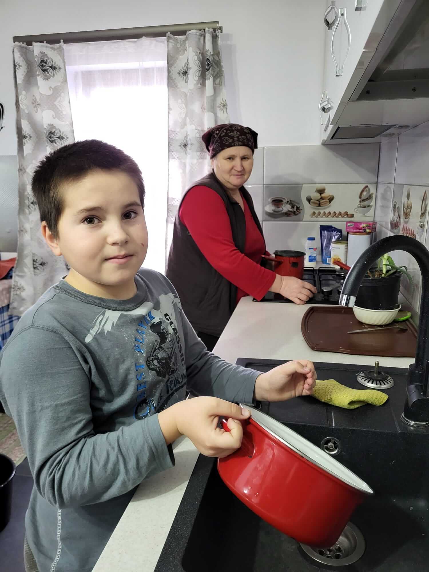 Ionut helps his grandmother with the dishes