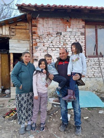 Yamur and her family outside their home in Bulgaria