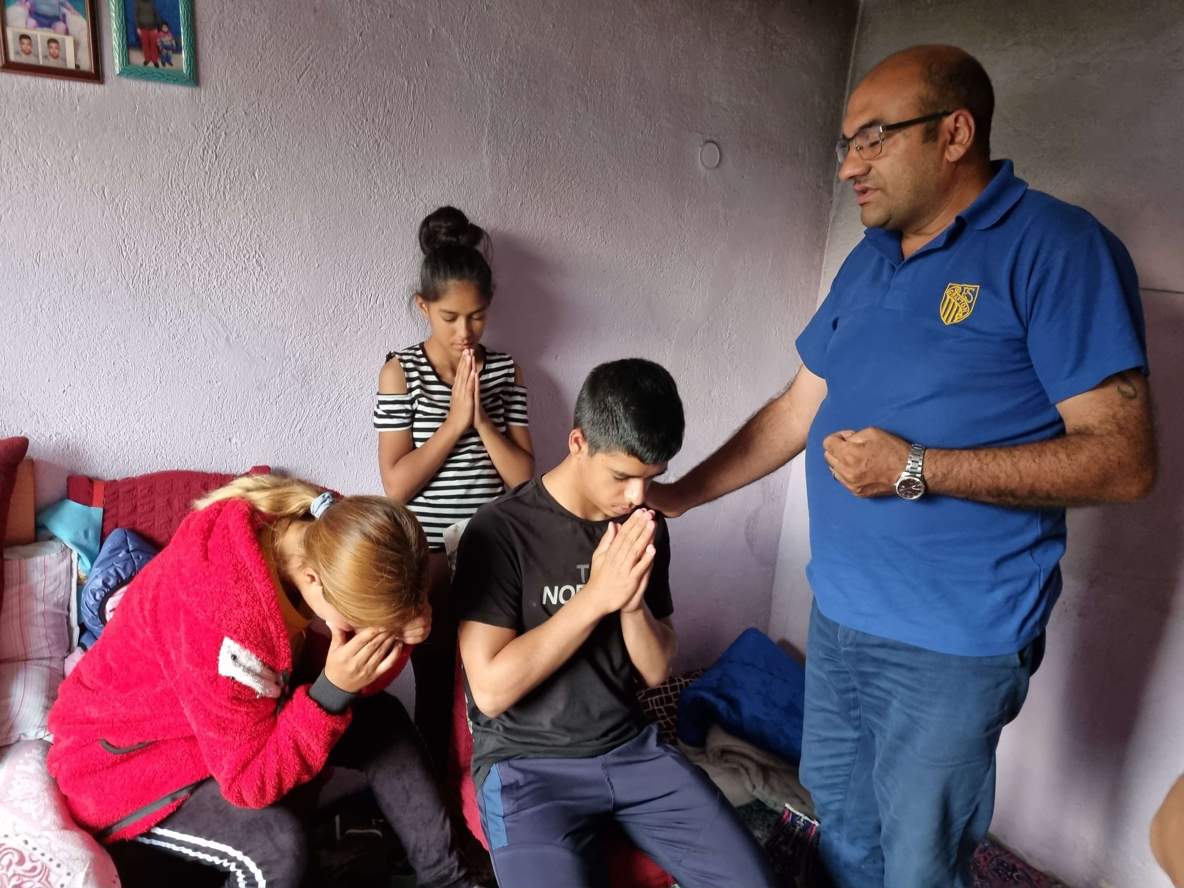Ventsislav prays with a family in the sponsorship program