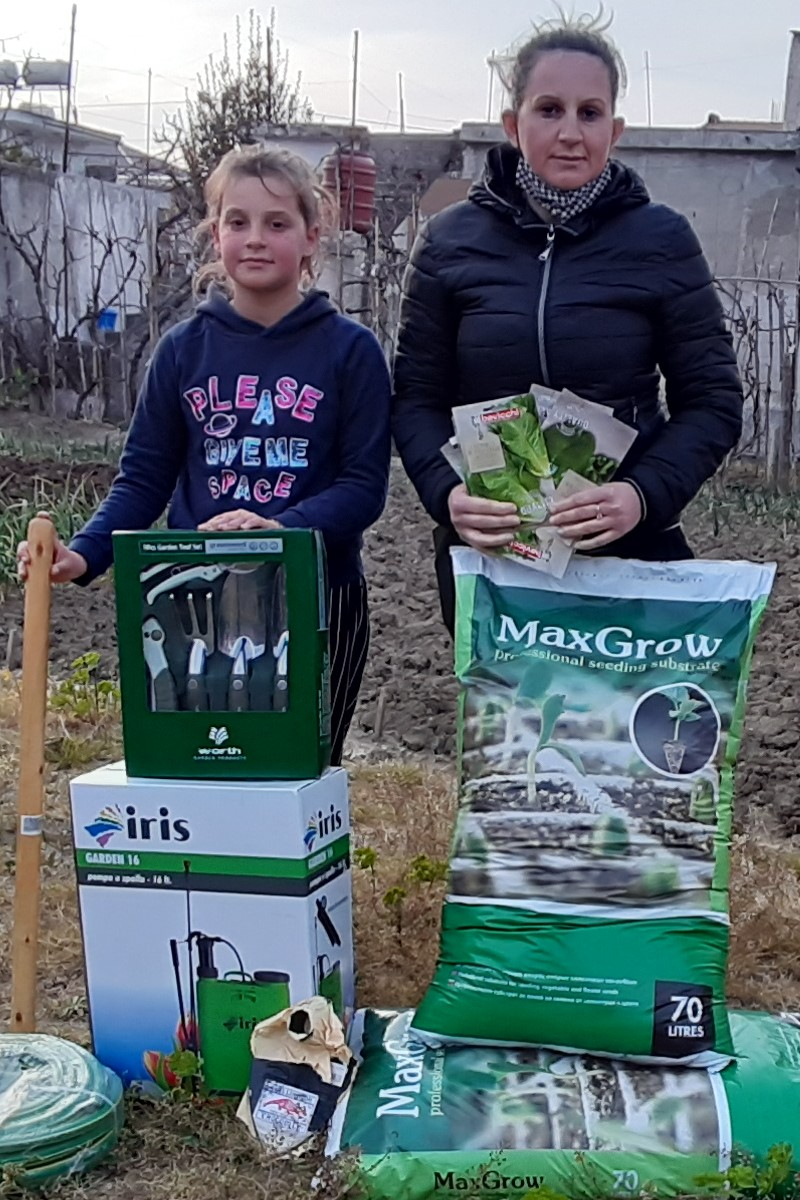 Daniela and her daughter  with gardening supplies the received via the Seeds and Tools program