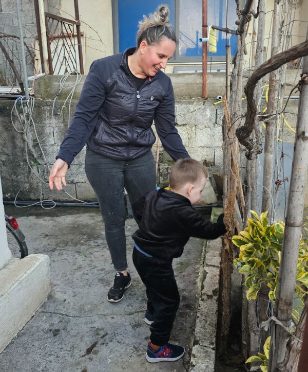 Daniella inspects their garden with her son